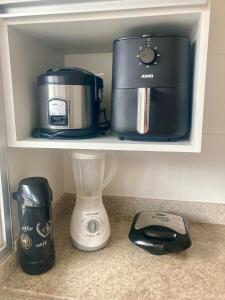 a shelf with a coffee maker and a blender on it at Conforto e espaço - 3 quartos, 3 vagas e a 150m do mar in Guarapari