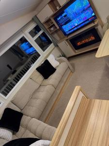 ein Wohnzimmer mit Couch und Flachbildfernseher in der Unterkunft Summer Breeze Deluxe in Skegness