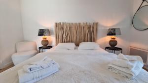 オロンにあるRésidence-Chalet de Prestige Aspen Park - 103のタオルが敷かれた白いベッドのある寝室