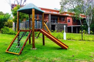 un parque infantil con un tobogán en un patio en ILHABELA PRAIA DO CURRAL Condômino VilaBela da Princesa en Ilhabela