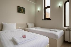 a room with two beds with a candle on a tray at Irbis hotel in Mestia