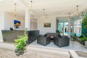 a living room with two couches and a tv at Teya Beach Hotel in Ahangama
