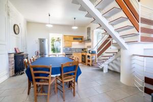 a kitchen and dining room with a blue table and chairs at Gîte des Fours à Chaux in Saumur
