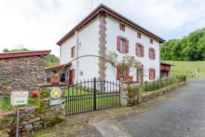a white house with a gate in front of it at Gite Etxaluzenea in Saint-Étienne-de-Baïgorry