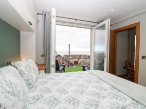 a bedroom with a bed and a large window at The Old Kipper Hoose in Gardenstown
