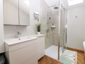 a white bathroom with a shower and a sink at The Old Kipper Hoose in Gardenstown +36 photos