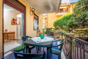 Un patio con una mesa y sillas en un balcón. en Casa Musa Giardini Naxos, en Giardini Naxos