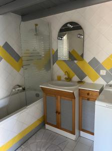 Un baño con lavabo, espejo y bañera. en Le Soleillant Havre De Paix, en LʼIsle-sur-la-Sorgue