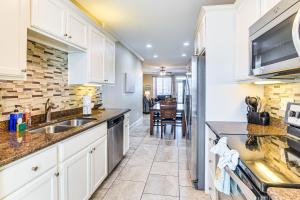 ガルベストンにあるPool Access and Balcony Beachfront Galveston Condo!の白いキャビネットとシンクのあるキッチン