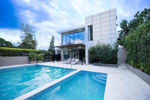 a swimming pool in front of a house at Pool & Gym - 10min Aeropuerto y HOMS - Dream Stay in Santiago de los Caballeros