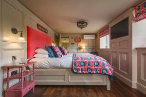a bedroom with a bed and a red wall at Ffolkes in Hillington +110 photos