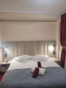 una camera da letto con un letto grande con due asciugamani sopra di Pensiunea ELEMAR ad Azuga