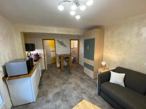 un soggiorno con un divano e una TV di studio classé à sommières a Sommières Altre 4 foto