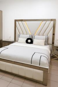 Un dormitorio con una gran cama blanca con una almohada negra. en Gelijkvloers appartement in hartje Menen, en Menen