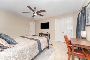 a bedroom with a bed and a table and a desk at Haven House-10 Min From PTI in Greensboro