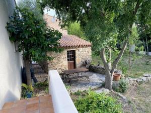 un edificio in pietra con una panchina in un cortile di studio classé à sommières a Sommières