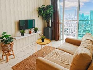 a living room with a couch and a tv at Newly Large 2BR Ambassador2 Apt with Pool Gym WiFi in Jakarta