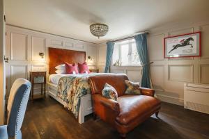 a bedroom with a bed and a leather chair at Ffolkes in Hillington