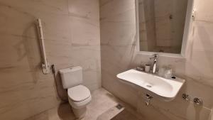 um banheiro branco com um vaso sanitário e uma pia em Hotel Bahia Redonda em El Calafate mais 37 fotografias