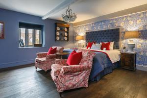 a bedroom with a bed and a couch and a chair at Ffolkes in Hillington