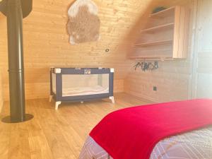 ein Schlafzimmer mit einem Bett und einer roten Decke auf dem Boden in der Unterkunft Gite Artense lodge in Saint-Genès-Champespe