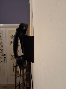 Ein schwarzer Ventilator steht auf einem Hocker neben einem Kühlschrank. in der Unterkunft Mascagni Rooms in Florenz