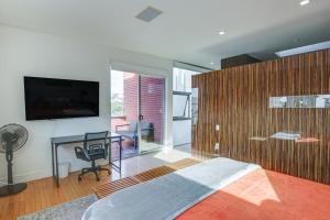 une chambre avec un lit, un bureau et une télévision dans l'établissement Walk to Harbor and Dining! Spacious San Diego Home, à San Diego