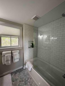 a bathroom with a tub and a window and towels at Tranquility Near Hudson & The Berkshires in Chatham
