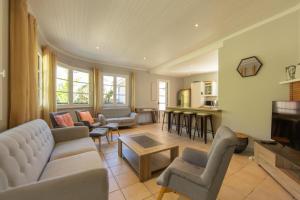 a living room with a couch and chairs and a table at Villa Du Phare avec piscine chauffée pour 14 perso in Cap-Ferret