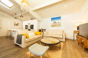 a living room with two couches and a table at Villa Du Phare avec piscine chauffée pour 14 perso in Cap-Ferret +58 photos