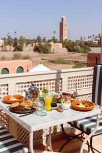a white table with food and drinks on a balcony at Riad Olma in Marrakech