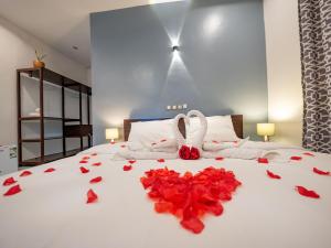 Natu Resort的一间卧室,床上有红色玫瑰