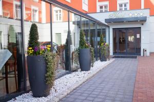 uma fila de vasos de plantas em frente a uma loja em Hotel przy Młynie em Rybnik