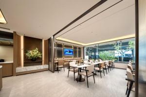 a dining room with tables and chairs and windows at Atour Hotel Shanghai Dapu Bridge ASE Center in Shanghai