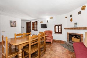 una sala da pranzo con tavolo e camino di La Cuadra a Málaga
