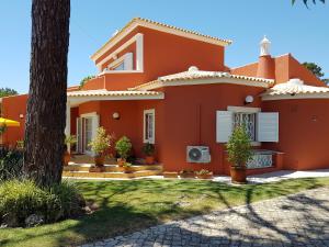 a orange house with a tree in front of it at Vila Luz in Vilamoura