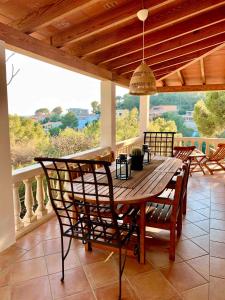 コスタ・デン・ブラネスにあるVilla Tramuntanaの木製のダイニングテーブルと椅子付きのポーチ