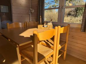 a dining room with a wooden table and chairs at Vedersø Strand Camping in Ulfborg