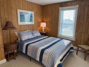 ein Schlafzimmer mit einem Bett und einer Lampe und einem Fenster in der Unterkunft 3 Bedroom 2 bath Beach House condo- 10 houses from the beach walk to the beach in Seaside Park