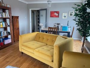 サウスポートにあるSouthport-Birkdale Luxury Havenの黄色いソファとテーブルのあるリビングルーム
