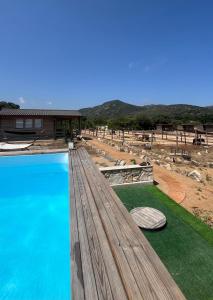 une vue d'une piscine avec une maison dans l'établissement Les Chalets De Tesa 4, à Occhiatana