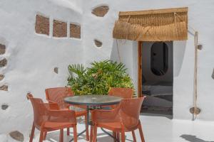 a patio with a table and chairs in front of a building at Arrieta Costa Rural in Tabayesco