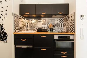 a kitchen with black cabinets and a stove at Appartment Christine in Lège city for 5 persons in Lège-Cap-Ferret