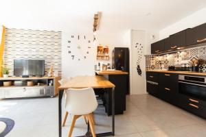 a kitchen with black cabinets and a wooden table at Appartment Christine in Lège city for 5 persons in Lège-Cap-Ferret +11 photos