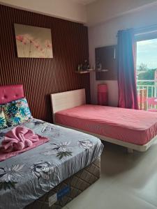 a bedroom with two beds and a window at Lelani's Comfy Condo in Mactan +11 photos