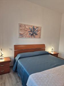 a bedroom with a blue bed and two lamps at Montecristo Sei in Follonica