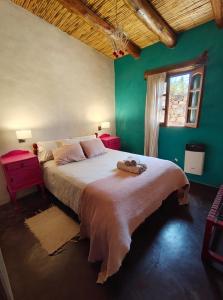 a bedroom with a large bed with green walls at Cabañas La rueda in Tilcara