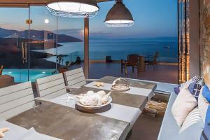 een eetkamer met uitzicht bij Vila Lina Syros in Azolimnos