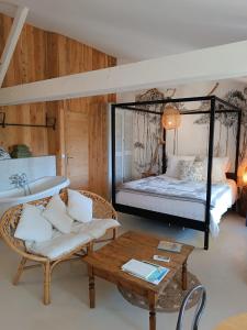 a bedroom with a bed and a couch and a table at Le Sens des Merveilles in Mane +18 photos