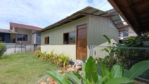 a small house with a wooden door in a yard at Downtown cabin for families in Macas in Macas